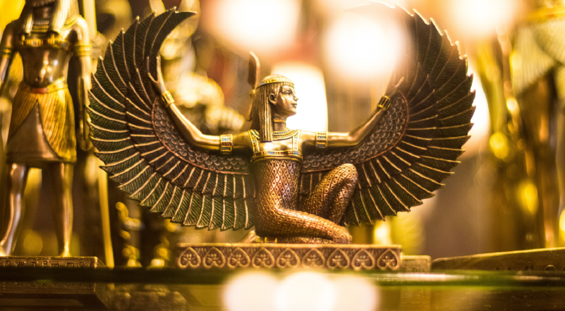 Photo of golden Egyptian statue of winged woman