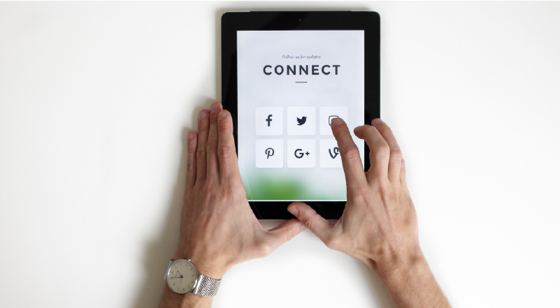 Photo of hands using ipad with social media icons