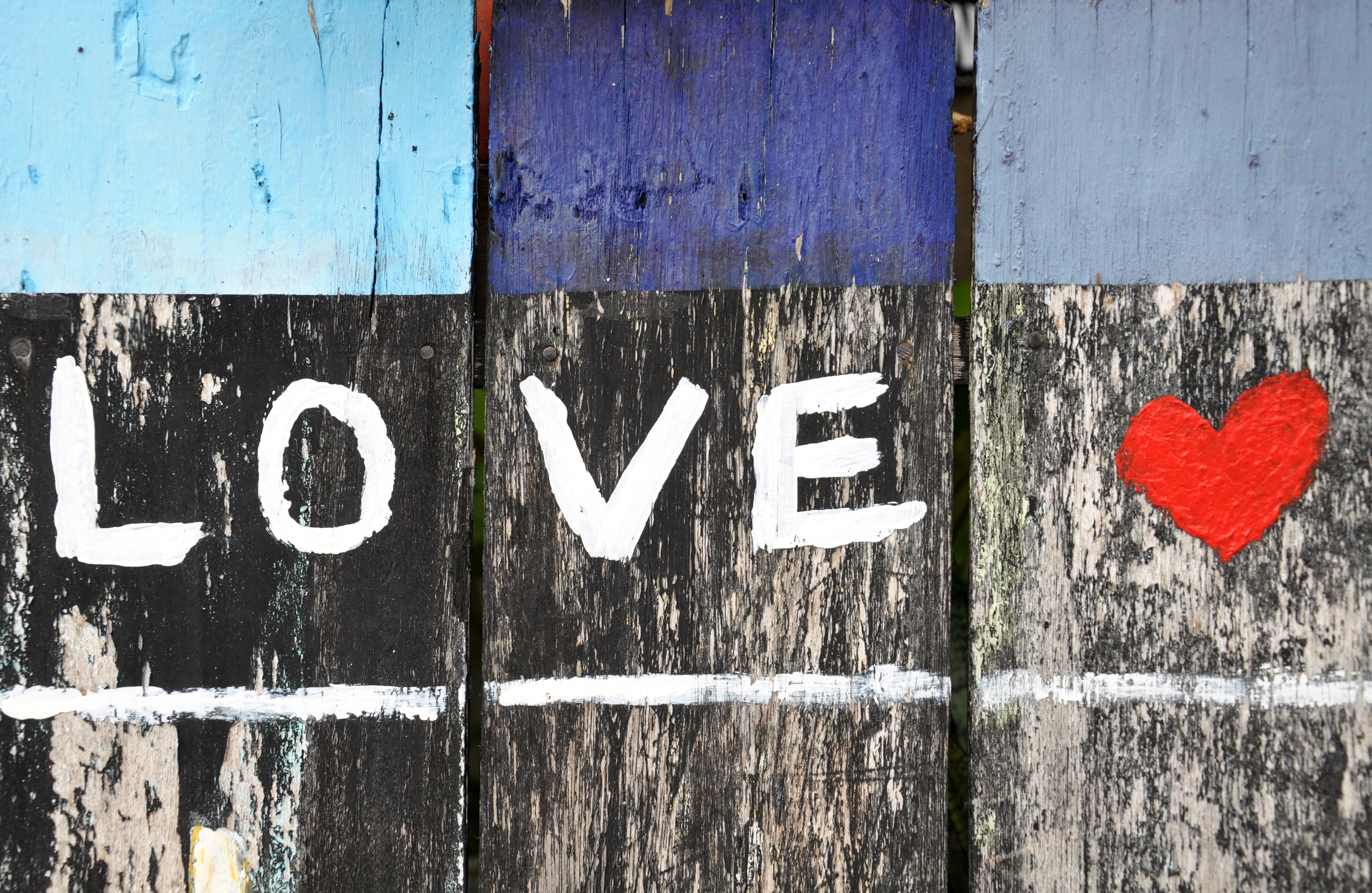 Wooden fence painted with word "love" and a red heart
