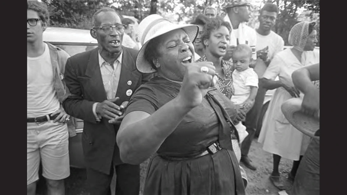 A group of people watching a woman sing.